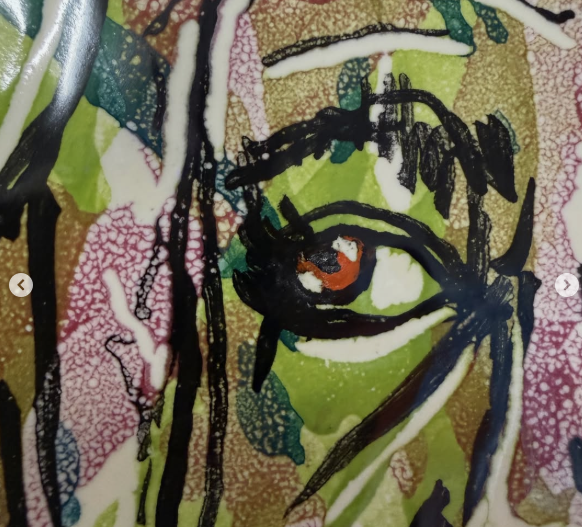 Detalle de cerámica: ojo pintado a tinta sobre esmalte verde